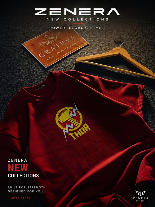 A dark red crewneck t-shirt featuring a yellow and white Thor's hammer graphic on the chest, styled on a dark textured background with a wooden hanger and a Grateva card. Zenera branding is prominent.
